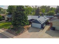 Charming single-Gathering home featuring solar panels, attached garage, and a driveway at 1648 S Locust St, Denver, CO 80224