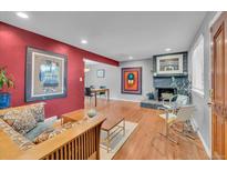 Inviting living room features a gray fireplace, hardwood floors, and charming furniture at 1648 S Locust St, Denver, CO 80224