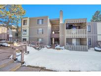Condo's exterior showcasing wood facade, a snow-covered front yard and wooden entryway feature at 2525 S Dayton Way # 1712, Denver, CO 80231
