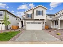 Charming two-story home features a two-car garage, landscaped yard, and a welcoming front entrance at 9243 Truckee Ct, Commerce City, CO 80022
