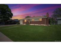 Charming brick home with a well-maintained lawn, mature trees, and inviting curb appeal at 392 Central Ave, Brighton, CO 80601