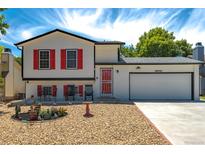 Charming two-story home featuring a well-maintained yard, red shutters and a two-car garage at 19630 E Purdue Pl, Aurora, CO 80013