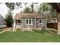 Charming gray home with a well-maintained lawn and a tire swing in the front yard at 2655 S Humboldt St, Denver, CO 80210