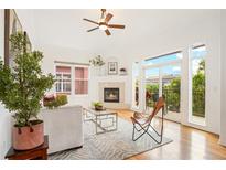 Bright living room featuring a fireplace, hardwood floors, and a sliding glass door to a private balcony at 2100 N Humboldt St # 302, Denver, CO 80205