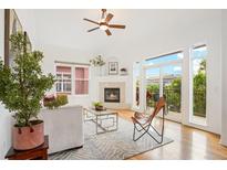 Bright living room featuring hardwood floors, a fireplace, and a sliding glass door to a balcony at 2100 N Humboldt St # 302, Denver, CO 80205