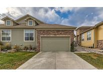 Inviting home showcasing a two-car garage with a charming stone facade and convenient driveway at 12715 Madison St, Thornton, CO 80241