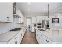 Modern kitchen featuring white cabinets, stainless steel appliances, and sleek countertops at 6733 S Waterloo Ct, Aurora, CO 80016