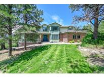 Beautiful two-story home with manicured lawn and mature trees providing curb appeal at 6681 Flintwood Rd, Parker, CO 80138