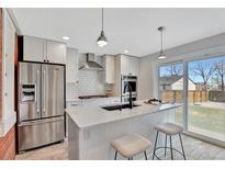 Modern kitchen features stainless steel appliances, white cabinets, and a large center island with seating at 4036 Navajo St, Denver, CO 80211