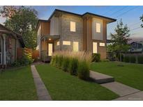 Striking two-story home with stone and wood accents, lush front yard, and inviting entrance at 2107 S Grant St, Denver, CO 80210