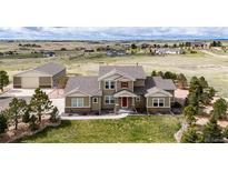 Inviting two-story home with a lush lawn, complemented by professional landscaping and a spacious detached garage at 575 Heritage Trl, Elizabeth, CO 80107