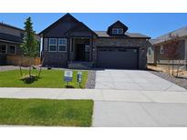 Beautiful two-story home featuring a well-manicured lawn and a two-car garage in a tranquil neighborhood at 6066 Caribou Dr, Brighton, CO 80601