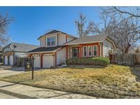 Charming two-story home features a well-manicured lawn and an attached two-car garage at 13294 W 65Th Dr, Arvada, CO 80004