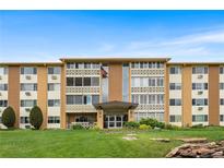 Inviting exterior of a tan and brown apartment building with manicured lawn and charming architectural details at 795 S Alton Way # 11C, Denver, CO 80247