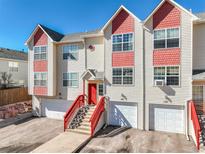 Inviting townhome showcasing a red staircase and a clean, two-car garage for convenient parking and curb appeal at 114 Vale St, Palmer Lake, CO 80133