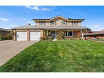 Charming two-story home featuring a well-manicured lawn and a two-car garage at 3191 S Holly Pl, Denver, CO 80222