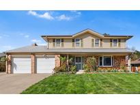 Charming two-story home with a well-manicured lawn, two-car garage, and light beige siding at 3191 S Holly Pl, Denver, CO 80222