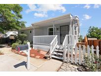 Charming single-Gathering home boasts a covered front porch and fenced yard at 1455 W Alaska Pl, Denver, CO 80223