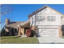 Charming two-story home featuring a brick facade, well-manicured lawn, and attached two-car garage at 11323 E Cimmarron Dr, Englewood, CO 80111