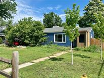 Charming blue house with tidy front yard and walkway leading to the entrance at 1701 W 50Th Ave, Denver, CO 80221