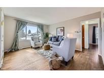 Bright living room with hardwood floors, large window, and comfortable seating arrangement at 1701 W 50Th Ave, Denver, CO 80221