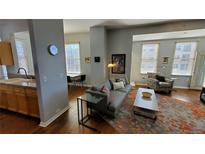 Bright living room with hardwood floors, stylish rug, and comfortable gray sofa at 475 W 12Th Ave # 8H, Denver, CO 80204