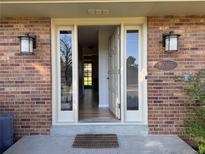 Inviting front entrance featuring a charming brick facade and updated exterior lights at 10366 E Ida Ave, Greenwood Village, CO 80111