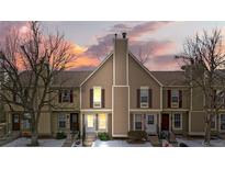 Tan-colored townhome exterior with a charming front entrance and landscaping at 1811 S Quebec Way # 151, Denver, CO 80231