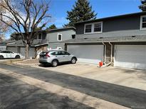 Charming townhomes with gray siding, stone accents, and attached garages on a sunny day at 2879 S Xanadu Way, Aurora, CO 80014