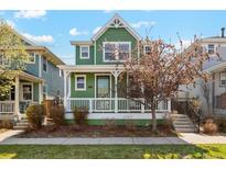 Charming two-story home with a welcoming front porch, green siding, and landscaped front yard at 3178 Geneva Ct, Denver, CO 80238