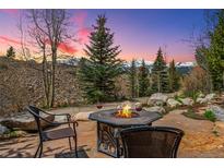 Enjoy outdoor living with a stone patio, fire pit, and mountain views at sunset at 200 Rachel Ln, Breckenridge, CO 80424