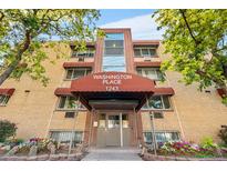 Exterior front view of Washington Place apartment building with brick facade and covered entry at 1243 N Washington St # 308, Denver, CO 80203