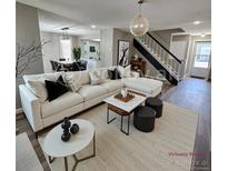 Bright living room featuring a white couch, modern decor, and hardwood floors at 2746 S Kenton Ct, Aurora, CO 80014