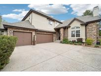 Stunning home exterior showcasing a three-car garage and stone accents at 1474 S Uinta Ct, Denver, CO 80231