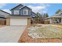 Charming two-story home featuring a blue exterior, brick accents, and a well-maintained front yard at 6452 Freeport Dr, Highlands Ranch, CO 80130