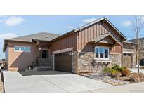 Beautiful home exterior featuring stone accents, wood siding, well-maintained landscaping, and a spacious driveway at 3598 New Haven Cir, Castle Rock, CO 80109