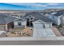 Charming exterior with three-car garage, gravel landscaping, and mountain view in the distance at 815 Alumroot St, Castle Rock, CO 80104