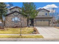 Charming two-story home featuring a stone facade, two-car garage, and well-maintained front yard at 16330 Avalanche Run, Broomfield, CO 80023