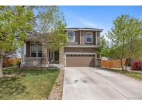 Beautiful home showcasing a well-maintained lawn, stone details, and an attached garage at 12616 Jersey W Cir, Brighton, CO 80602