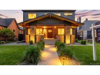 Stunning two-story home with a brick facade, inviting front porch, and lush green lawn with inviting walkway at 2669 N Cherry St, Denver, CO 80207
