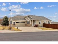Inviting single-story home features a two car garage, neutral siding, and a well-maintained lawn at 16791 Rolling Hills Pl, Parker, CO 80134