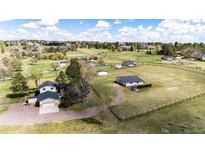 Expansive aerial view of a home with pastures, outbuildings, and fencing at 17800 E Hinsdale Ave, Foxfield, CO 80016