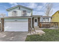 Charming two-story home featuring a brick and siding exterior, a well-kept lawn, and an attached garage at 19485 E Purdue Pl, Aurora, CO 80013