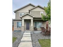 Charming two-story home with stone accents, covered porch, and manicured front yard at 11709 Park South Ln, Parker, CO 80138