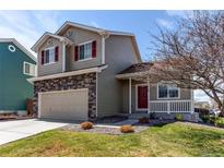 Charming two-story home featuring stone accents, a well-manicured lawn, and a welcoming front porch at 5549 Helena St, Denver, CO 80239