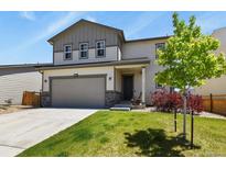 Charming two-story home featuring a well-manicured lawn, attached garage, and a welcoming front porch at 6404 Dry Fork Dr, Frederick, CO 80516