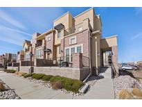 Charming townhome with brick and stucco exterior, featuring a cozy front porch and well-maintained landscaping at 9225 Rockhurst St # A, Highlands Ranch, CO 80129