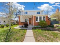Charming two-story home with brick accents, a well-manicured lawn, and a welcoming front porch at 2675 Quitman St, Denver, CO 80212