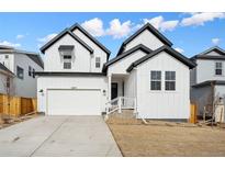 Charming two-story home with white siding, black trim, and well-manicured lawn on a sunny day at 16633 W 93Rd Way, Arvada, CO 80007