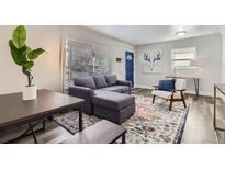 Bright living room with modern decor, hardwood floors, and a large window at 3385 Olive St, Denver, CO 80207